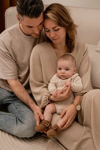 Lifestyle newborn fotoshoot in Voorhout, intieme beelden van ouders met hun pasgeboren kindje, vastgelegd in eigen huis.