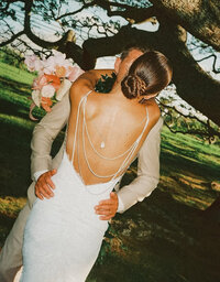 bride and groom standing in front of banana trees