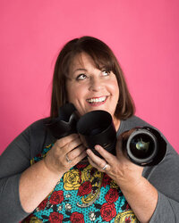 woman smiling and holding a camera