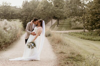 Bride and groom kissing on path