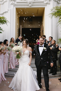 Bride in a mermaid dress leaves the chapel with her husband after wedding ceremony | Sush Digital Media