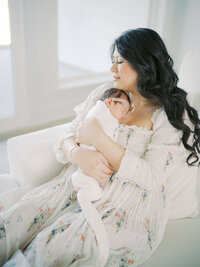 a mother cradles her newborn to her chest