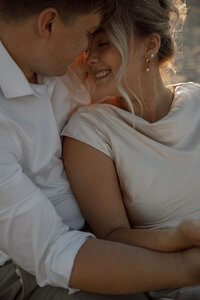 couple embraces for engagement photos in san diego
