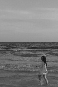 Michaela walking on the beach in a black and white photo in Santa Rosa Beach, FL. 