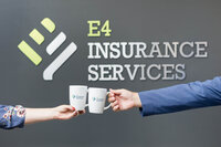 two people clinking mugs with an insurance company logo on it