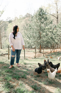 Woman standing in her garden with her chickens