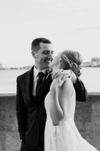 A newlywed with their arm around their partner's shoulder as they hold hands 