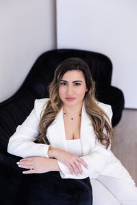 Yudielis Sánchez sentada en sofá negro con suit blanco.