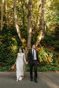 Bride and groom walking at sunset with a flowing veil and mountain backdrop, captured by a Washington wedding photographer.