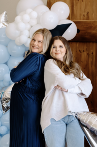 2 girls standing back to back with crossed arms