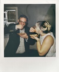 Couple eating hot wieners at their wedding.