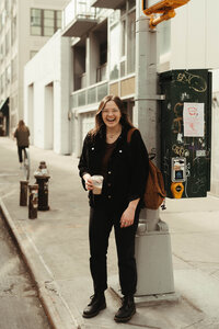 woman smiling while holding a coffee cup