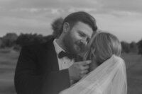 A person reaching towards their partner's cheek as they are about to kiss