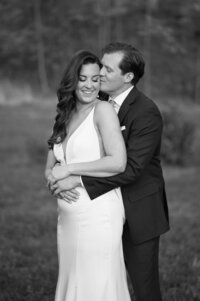 A person standing behind their partner with their arms around their waist
