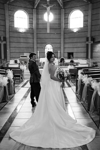 Bride and groom standing together outside a Catholic church in Colorado Springs after their wedding ceremony.
