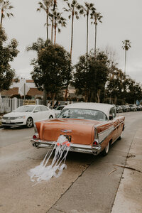 Vintage getaway car with just married decor under palm trees in Long Beach, coordinated by Beyond the Event and photographed by Kellie Jane Photography.