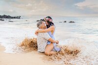 couple hold hands on the beach at sunrise on maui