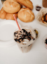 chocolate iced drink with a red and white pin stripe straw
