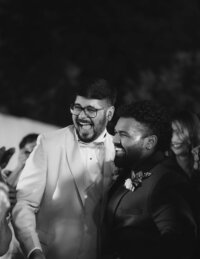 Two grooms smiling at their wedding, representing how The Crush Collective wedding expo is LGBTQ friendly.