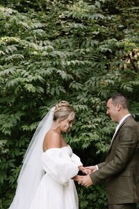 Film photo of bride and groom holding hands in front of bush by elopement photographer washington state
