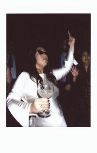 Polaroid photo of a bride dancing in sunglasses at her Boston wedding reception, holding a cocktail and celebrating — a candid moment captured by a film wedding photographer.