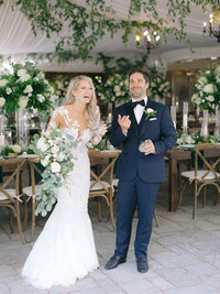 bride and groom share a joyful moment amidst the beautifully decorated reception area with lush florals and rustic elegance