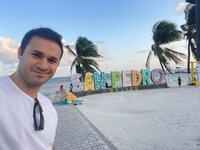 Happy traveler takes a picture with the colorful San Pedro, Belize landmark sign