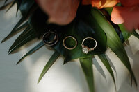 A close-up of stunning diamond wedding rings, carefully placed on an elegant floral backdrop at a luxury destination wedding in Mexico.