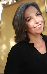woman with short gray hair standing outside smiling