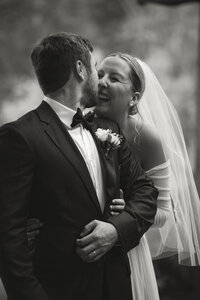 bride and groom kissing with a forest background