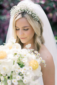 Bride in baby’s breath floral crown holding soft spring bouquet, styled by Northeast Florida wedding planner The Eventful Gals.