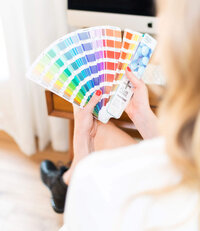 Brand Designer Holding Pantone Swatch Books - Create & Wander