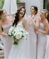 Bridesmaids cheering and celebrating with the bride on the beach at a tropical wedding