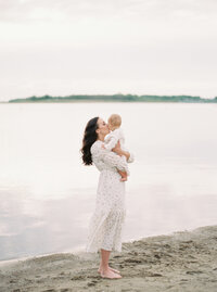 Mother kissing baby on beach Denver Family Newborn Photographer