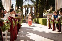 Flower girl walks down the aisle throwing petals