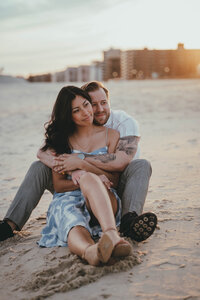 man and woman sitting on a beach embracing