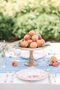 Peaches and fresh fruit stacked on cake tray for elegant brunch