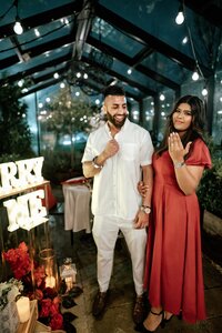Styled glasshouse proposal for Harneet and Simmeran featuring a romantic dining table with candles, red floral arrangements, and elegant décor, captured by Zanthe Vorsatz.