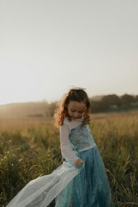 Red-haired girl twirling in dress | child joy and growth supported by educational evaluations in Santa Barbara
