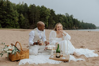 bride and groom having a picnic on a beach on Lake Superior