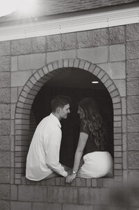 A man giving his girlfriend a piggy back ride on top of a parking garage.