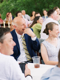 Parents of the groom laugh during toasts at the wedding reception.