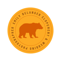 Yellow circle badge with an orange bear and maroon font reading "Emily Belanger Elopement & Wedding Photographer" circling picture