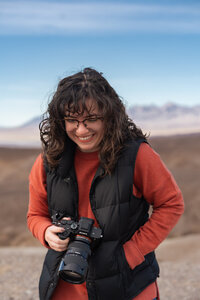 A person laughing while holding a camera