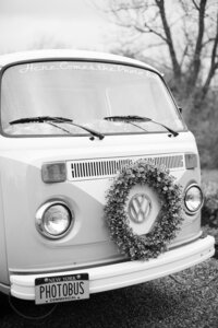 front of vintage VW van with small wreath around the emblem