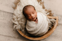 mom and dad cuddling baby in newborn session in studio