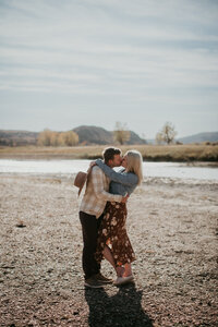 A romantic engagement portrait taken in the iconic Badlands of Medora, ND. The vast landscape serves as a stunning backdrop for a couple in love, capturing the essence of their engagement in the heart of the North Dakota wilderness.