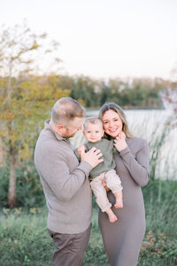 Couple holding baby boy in Carrollwood Village Park for Tampa Fall Mini Session.