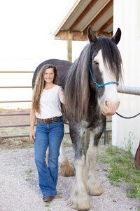 Missoula Montana equine photoshoot with draft horse and woman wearing white shirt and jeans