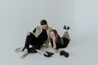 Bre and Clay in all white space looking at their laptop